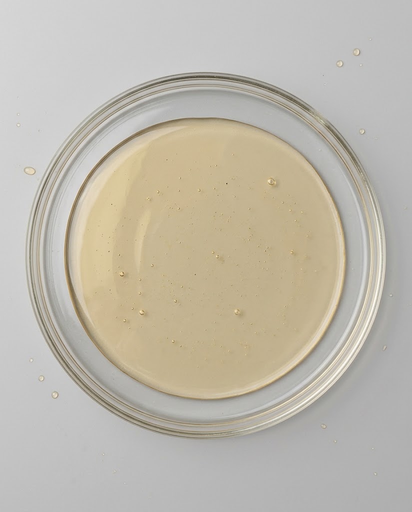 Jojoba oil pooled in a shallow glass dish